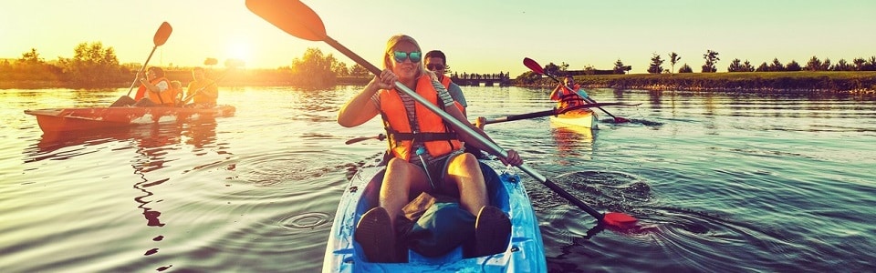 Wild nature and water fun on summer vacation. Camping and fishing. Kayaking and canoeing with family. Children on canoe. Family on kayak ride.