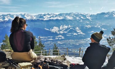 deux femme de dos lors d'une randonnée en raquette pause vue montagne