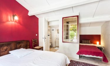 Chambre charmante avec 2 lits et un mur rouge
