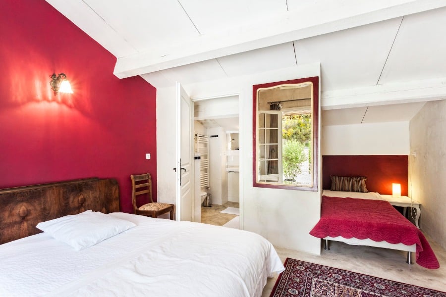 Chambre charmante avec 2 lits et un mur rouge